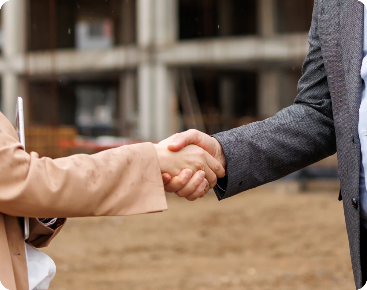 Two people shaking hands outside